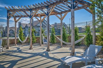 a seating area with hammocks and a pergola